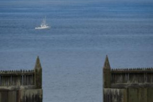 Small fishing boat in the pacific ocean, looking through the gates of Fort Ross