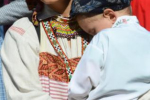 Traditional Russian attire, child sleeping against his mother at Fort Ross