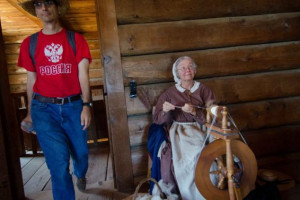 Woman in traditional attire spinning wool at Fort Ross